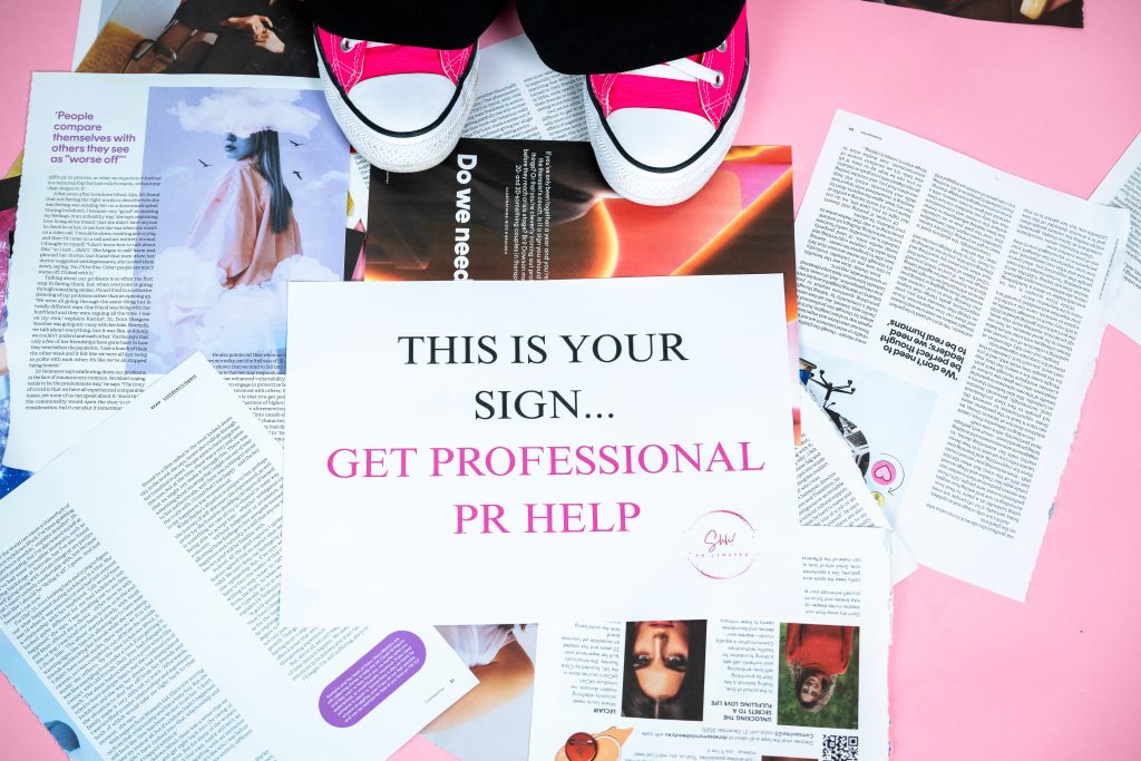 Magazines spread around Amies feet with a Shh pr sign