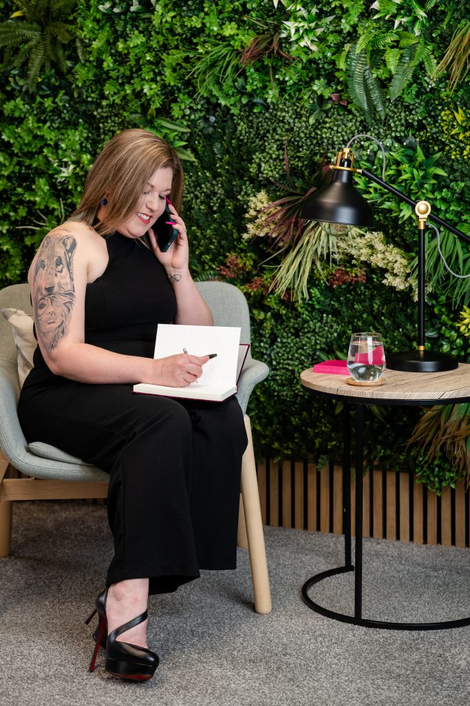 Ambitious founder on the phone to team talking through next steps while making notes in a notebook